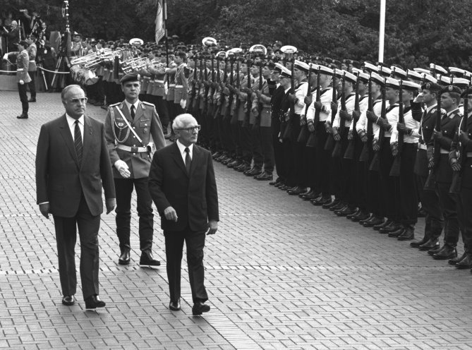 Vom 7. bis 11. September 1987 besucht der Staatsratsvorsitzende der DDR Erich Honecker (Bildmitte), zum ersten Mal die Bundesrepublik und wird von Bundeskanzler Helmut Kohl (links) vor dem Bundeskanzleramt mit militärischen Ehren empfangen. Quelle: REGIERUNGonline/Lothar...