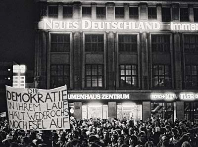 Montagsdemonstration in Leipzig am 23. Oktober 1989: Das ironische Transparent zeigt die Abwandlung eines Ausspruchs von Erich Honecker: „Den Sozialismus in seinem Lauf hält weder Ochs noch Esel auf."