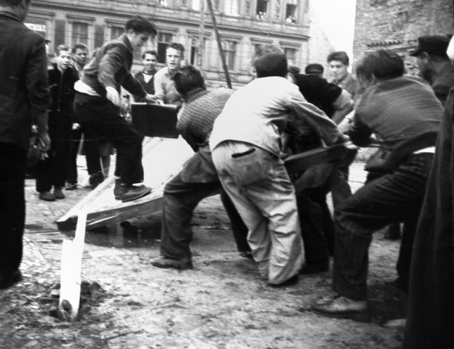 An der Sektorengrenze in der Friedrichstraße reißen Demonstranten ein Sektorenschild nieder. Quelle: REGIERUNGonline/Perlia-Archiv