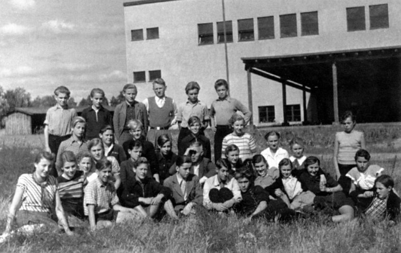 Ein Foto aus unbeschwerten Tagen: Die Klasse 9 der Kurt-Scheffel-Oberschule in Storkow im Schuljahr 1953/54. Das neue Schulgebäude im Hintergrund wurde aus den Steinen zerbombter Häuser der Stadt errichtet. Quelle: Privat-Archiv Dietrich Garstka