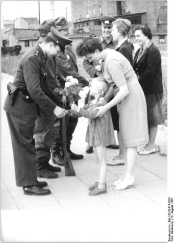 15. August 1968. Das DDR-Propagandafoto soll die Zustimmung der Bevölkerung zum Mauerbau zeigen. Am Kontrollpunkt Heinrich-Heine-Straße werden Blumen und kleine Geschenke an Grenzposten überreicht.