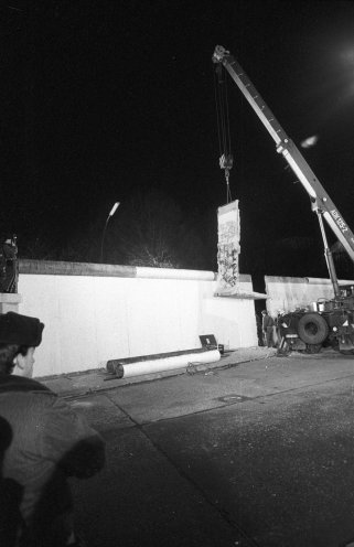 Auf der DDR-Seite beginnen am 21. Dezember 1989 die Abrissarbeiten zum Mauerdurchbruch am Brandenburger Tor. Kurz nach Mitternacht laufen die Vorbereitungen zur Öffnung der Mauer am Brandenburger Tor an. Um 0.30 Uhr wird das erste Betonteil aus der Verankerung...