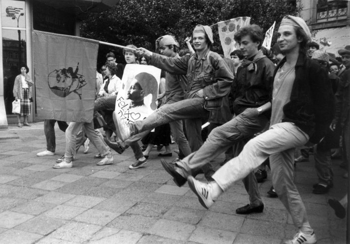 Öffentliche Straßenaktion der Orange Alternative (Pomaranczowa Alternatywa), vermutlich anlässlich des 70. Jahrestags der Oktoberrevolution 1987. Man sieht die Teilnehmer in ihren Heizelmännchenkostümen, dem Wiedererkennungsmerkmal der PA. Quelle:...