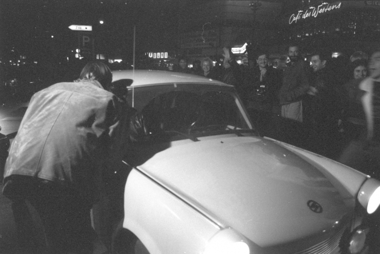 Westberliner begrüßen die DDR-Bürger in der Nacht des 9. Novembers 1989 auf dem Kurfürstendamm. Im Hintergrund ist die Leuchtreklame des Cafés des Westens zu erkennen. Quelle: Robert-Havemann-Gesellschaft/Jörg Metzner/RHG_Fo_JM_F152-36