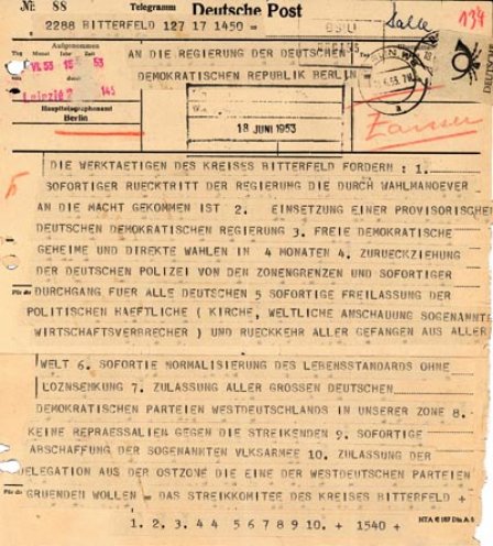 Telegramm an die Regierung der DDR: Der Lehrer Wilhelm Fiebelkorn verliest auf der zentralen Kundgebung in Bitterfeld die Forderungen des Streikkomitees. Die Menge stimmt begeistert zu und singt die dritte Strophe des Deutschlandlieds. Wilhelm Fiebelkorn...