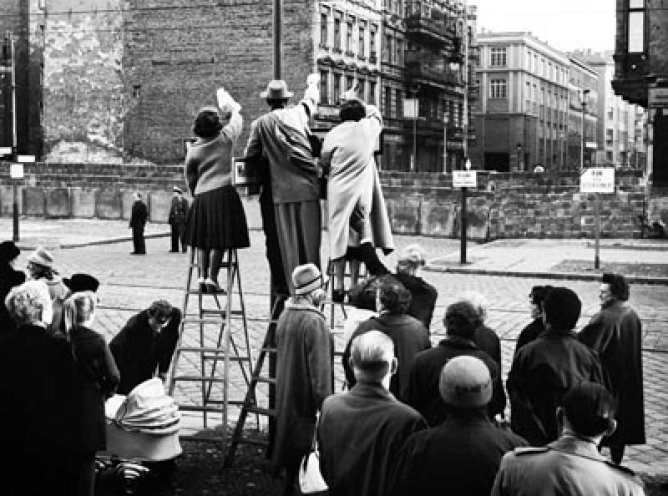 Die Mauer teilt nicht nur eine Stadt, sondern auch ganze Familien. Am 20. Oktober winken Westberliner in der Bernauer Straße ihren Familienangehörigen im Osten zu.