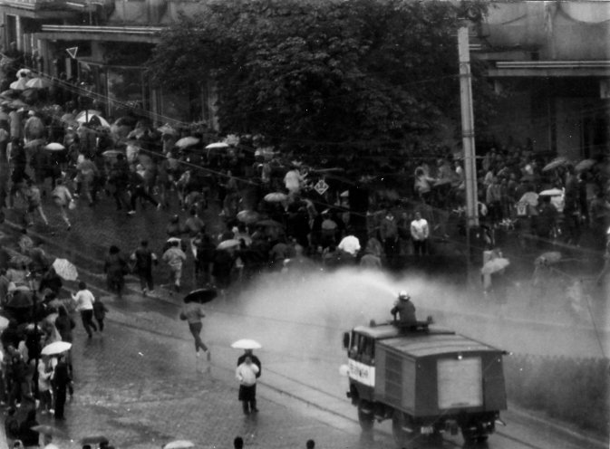 Die Einsatzleitung der Volkspolizei ist völlig überfordert und lässt Löschfahrzeuge der Feuerwehr Plauen als Wasserwerfer einsetzen, um die Leute auseinanderzutreiben. Doch auch die Wasserwerfer können den Demonstrationszug nicht aufhalten. Quelle:...