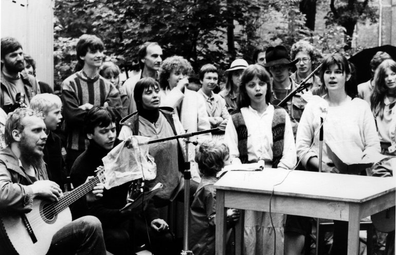 Reinhard Schult (links mit Gitarre) während einer Friedenswerkstatt auf dem Gelände der Berliner Erlöserkirche. Quelle: Robert-Havemann-Gesellschaft/Hartmut Beil/RHG_Fo_HAB_16054