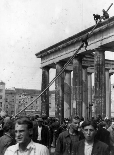 Junge Arbeiter klettern auf das Brandenburger Tor und entfernen die die rote Fahne.