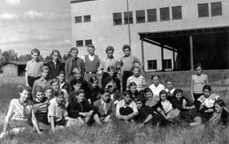 Ein Foto aus unbeschwerten Tagen: Die Klasse 9 der Kurt-Scheffel-Oberschule in Storkow im Schuljahr 1953/54. Das neue Schulgebäude im Hintergrund wurde aus den Steinen zerbombter Häuser der Stadt errichtet.