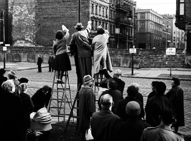 Die Mauer teilt nicht nur eine Stadt, sondern auch ganze Familien. Am 20. Oktober winken Westberliner in der Bernauer Straße ihren Familienangehörigen im Osten zu. Quelle: REGIERUNGonline/Klaus Schütz