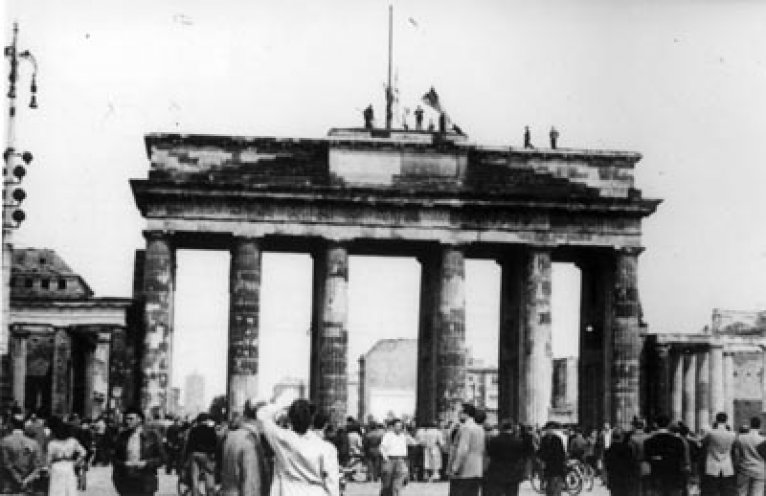 Demonstranten entfernen die rote Fahne vom Brandenburger Tor, verbrennen sie und ersetzen sie durch drei schwarz-rot-goldene Flaggen.