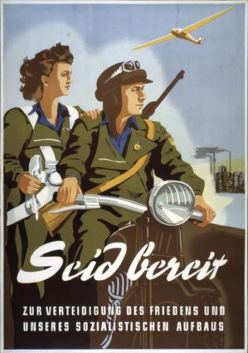 Ein Werbeplakat für die GST: Über die im Sommer 1952 gegründete Gesellschaft sollen Jugendliche auf ihre künftige Soldatenrolle vorbereitet werden. Die GST wirbt mit attraktiven Wehrsportprogrammen wie Segelfliegen, Kleinkaliberschießen und Fallschirmspringen.