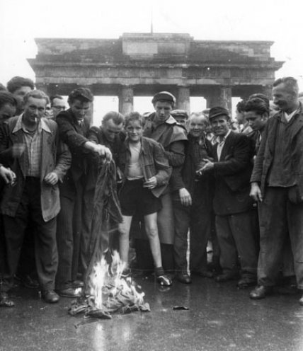 Demonstranten verbrennen die Rote Fahne.