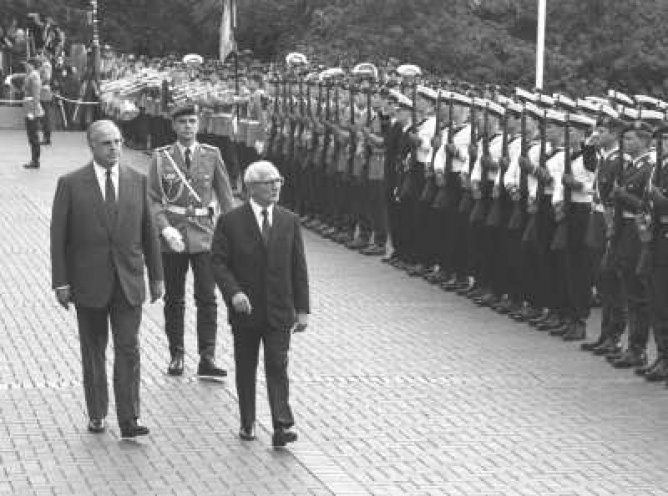 Vom 7. bis 11. September 1987 besucht der Staatsratsvorsitzende der DDR Erich Honecker (Bildmitte), zum ersten Mal die Bundesrepublik und wird von Bundeskanzler Helmut Kohl (links) vor dem Bundeskanzleramt mit militärischen Ehren empfangen.