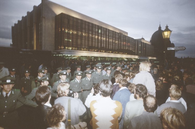 Vor dem Palast der Republik, in dem die Feierlichkeiten zum 40. Jahrestag stattfinden, treffen die Demonstranten auf die Absperrketten der Polizei. Die Rufe der Demonstranten nach Reformen sind auch in den Innenräumen des Palastes zu hören. Doch dort...