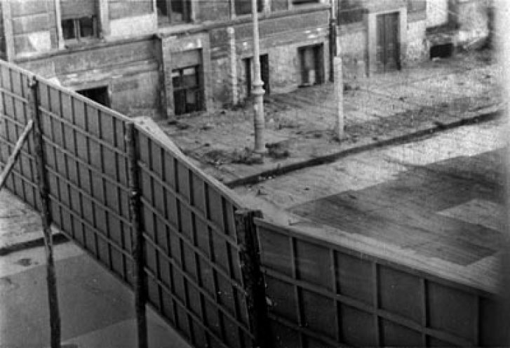 September 1961, Blick aus dem Fenster einer Wohnung in der Ostberliner Wolliner Straße Nr. 21. Die provisorische Holzwand dient als Sichtblende für Westberliner und auf der anderen Seite als Propagandatafel für die Ostberliner. Die Mauer findet erst...