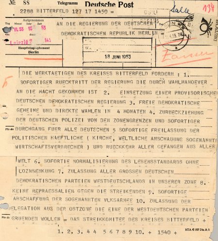 Telegramm an die Regierung der DDR: Der Lehrer Wilhelm Fiebelkorn verliest auf der zentralen Kundgebung in Bitterfeld die Forderungen des Streikkomitees. Die Menge stimmt begeistert zu und singt die dritte Strophe des Deutschlandlieds. Wilhelm Fiebelkorn...