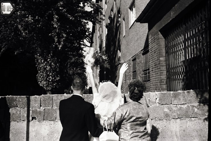 Am 23. August 1961 winkt ein Brautpaar im Bezirk Berlin-Neukölln seinen Angehörigen im Osten zu. Quelle: REGIERUNGonline/Klaus Lehnartz
