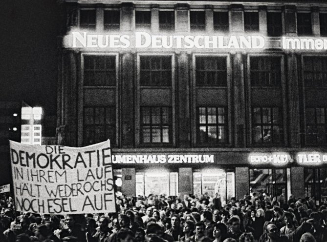 Montagsdemonstration in Leipzig am 23. Oktober 1989: Das ironische Transparent zeigt die Abwandlung eines Ausspruchs von Erich Honecker: „Den Sozialismus in seinem Lauf hält weder Ochs noch Esel auf." Quelle: REGIERUNGonline/Liebe