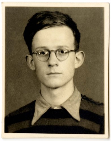 Auf dem Schwarz-Weiß-Porträtfoto ist ein Jugendlicher zu sehen. Er trägt eine runde Brille, einen gestreiften Pullover, darunter ein Hemd mit Kragen, seine Haare sind ordentlich gekämmt. Er blickt direkt in die Kamera.