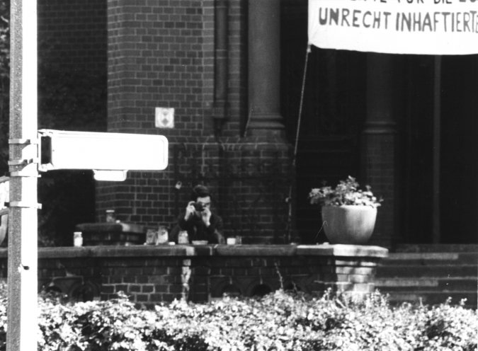 Fotoduell: Während der Mahnwache in der Gethsemanekirche observiert die Stasi die Umgebung und fotografiert Frank Ebert, der wiederum die Stasileute fotografiert. Quelle: BStU, MfS, BV Berlin, Fo 30, Bild 6