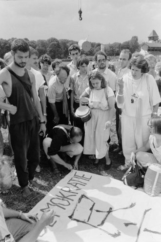 Frank Sellenthin (links, stehend) und Uwe Schwabe (mitte, kniend) bei den Vorbereitungen zur Demonstration auf der Abschlussveranstaltung des Kirchentages der Evangelischen Landeskirche Sachsen am 9. Juli 1989 in Leipzig. Mit dem chinesischen Schriftzeichen...